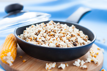 Popcorn cooked in a frying pan and ear of maize
