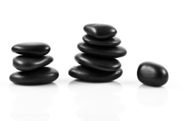 Black massage stones stacked, isolated.