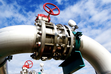 Industrial zone, Steel pipelines and valves against blue sky