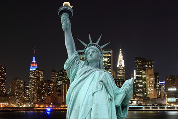Fototapeta premium Manhattan Skyline and The Statue of Liberty at Night