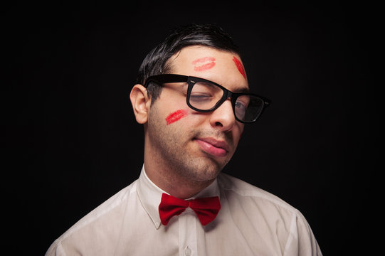 Funny portrait of young nerd with kiss imprints blinking eye 