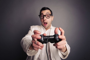 Fototapeta na wymiar Młoda frajerem w okularach trzyma joystick i gier