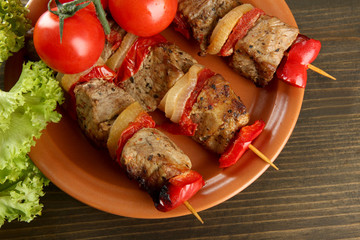 tasty grilled meat and vegetables on plate, on fire background