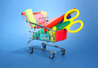 trolley with school equipment on blue background