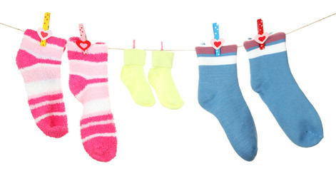 Colorful socks hanging on clothesline, isolated on white