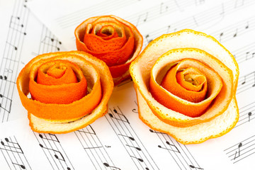Decorative rose from dry orange peel on musical notes
