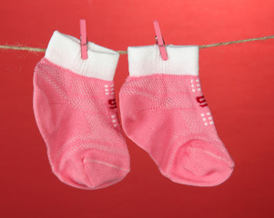 Colorful socks hanging on clothesline, on color background