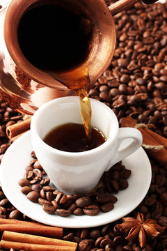 Cup and pot of coffee on coffee beans background