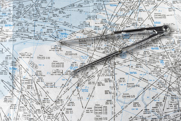A pair of compasses on an aeronautical navigational chart