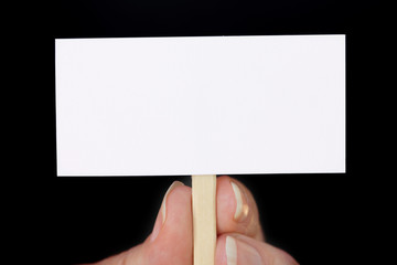 Hand Holding Tiny Sign on Black