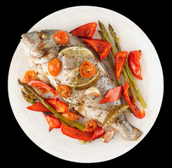 Roasted gilt-head bream with vegetables on plate, isolated on wh