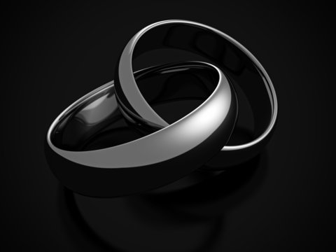 silver wedding rings on dark black background