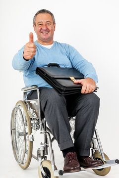 Friendly man in wheelchair holding thumbs up