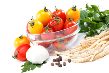 Tomatoes in a glass plate, garlic and parsley isolated on white