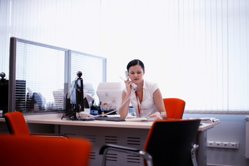 beautiful girl in a white shirt sitting a modern office