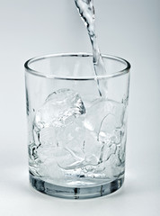 Water flowing onto ice in glass