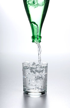 Water flowing from bottle into glass