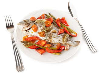 Roasted gilt-head bream with vegetables on plate, isolated on wh