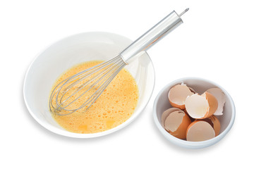 eggs yolk with whisk, isolated on white