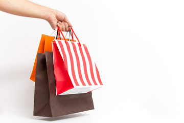Holding shoping bags by hand on white isolate