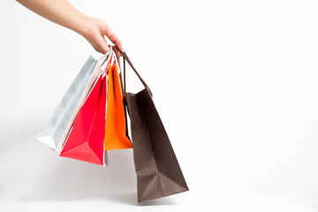 Holding shoping bags by hand on white isolate