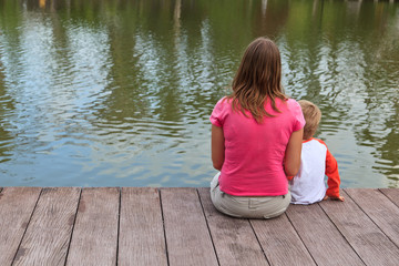 family sitting on  the lake