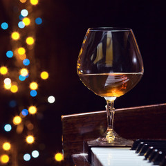 snifter with brandy on a piano
