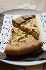 Two slices of vegetarian tart with zucchini, onion and tofu