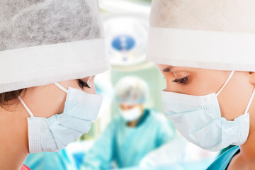 Fototapeta premium Two female surgeon with nurse in operation room