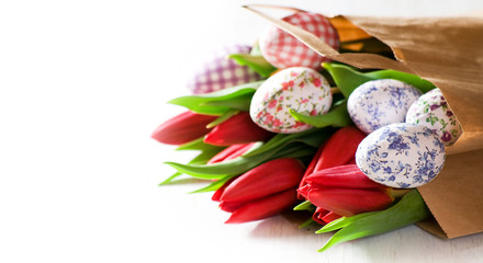 Image of decorative Easter eggs and tulips in brown bag