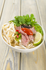 Pho Bo - Vietnamese rice noodle soup with beef, herbs and chili © paul_brighton