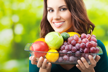 Woman with plate of fruits, outdoors