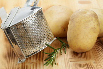 Kartoffelpresse und Kartoffeln