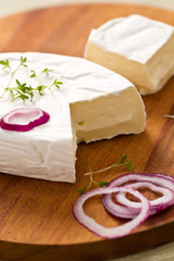 Aufgeschnittener Weichkäse auf Holzbrett