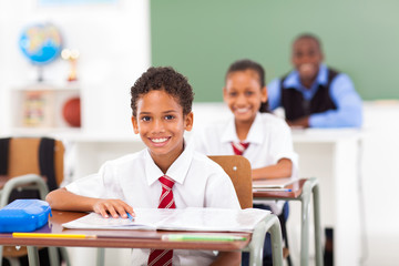 primary students and teacher sitting in classroom