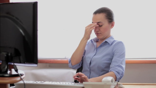 Young business woman with myopia sitting at computer