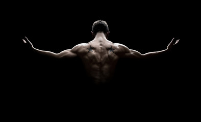 Rear view of healthy young man with arms stretched out - obrazy, fototapety, plakaty