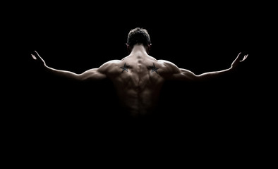 Rear view of healthy young man with arms stretched out