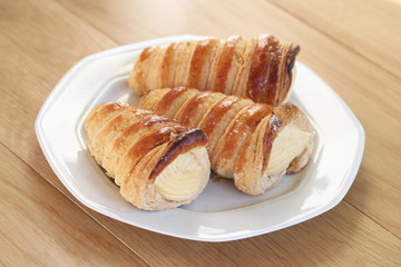 tre cannoli alla crema su piatto