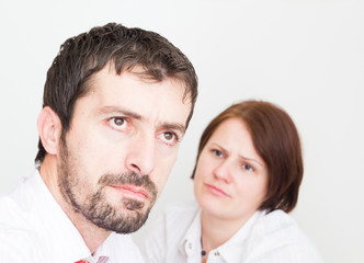 Portrait of upset young couple sitting seperately in the bedroom
