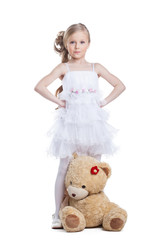 Cute little girl with teddy bear posing in studio