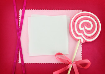 Blank card with lollipop on pink background