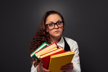 serious young woman in glasses offering books