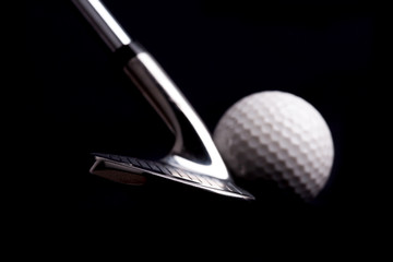 golf  club  with ball on black background