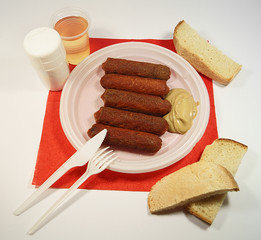 Grilled sausages on a disposable container.