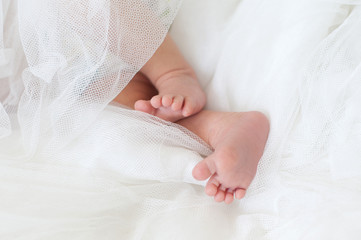Obraz na płótnie Canvas Baby feet in a white diaper
