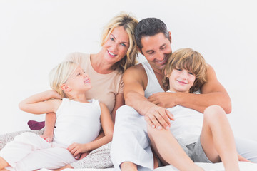 Family posing on a bed
