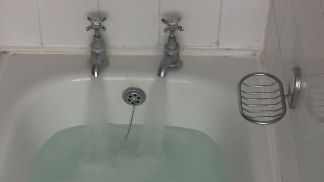 Hot and cold bath taps being turned off.