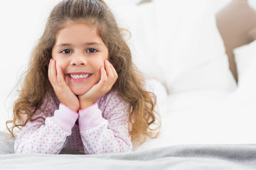 Naklejka premium Cute girl lying on bed