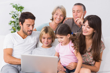 Fototapeta na wymiar Szczęśliwa rodzina patrząc na laptopa